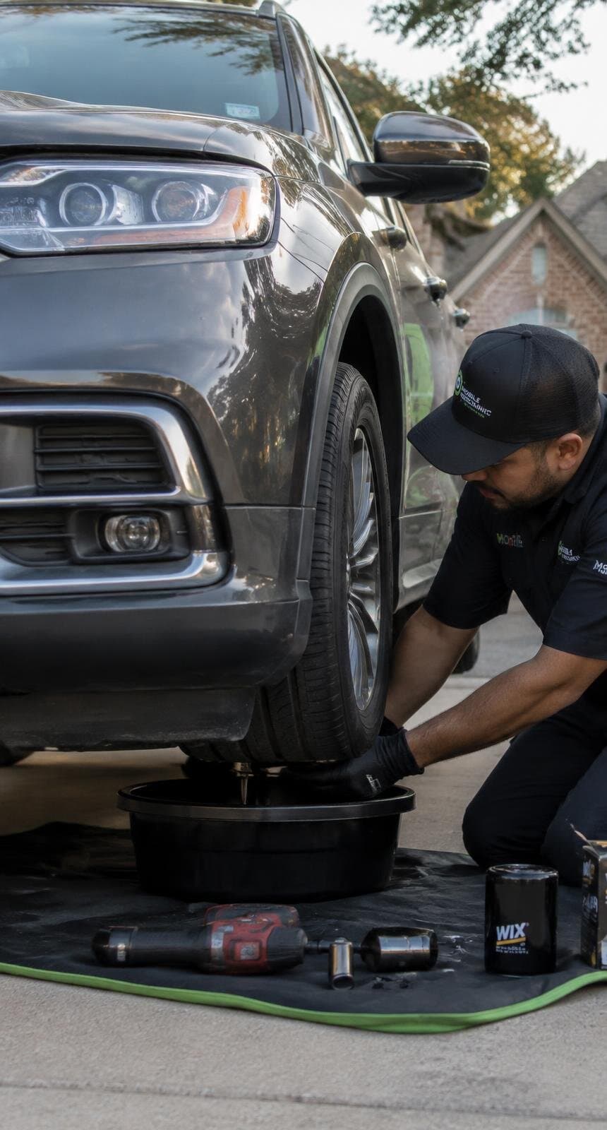 A mobile technician servicing a vehicle in a residential driveway